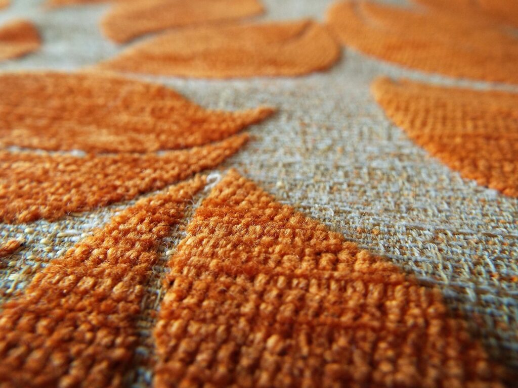 A clean carpet featuring orange shapes and brown matting.